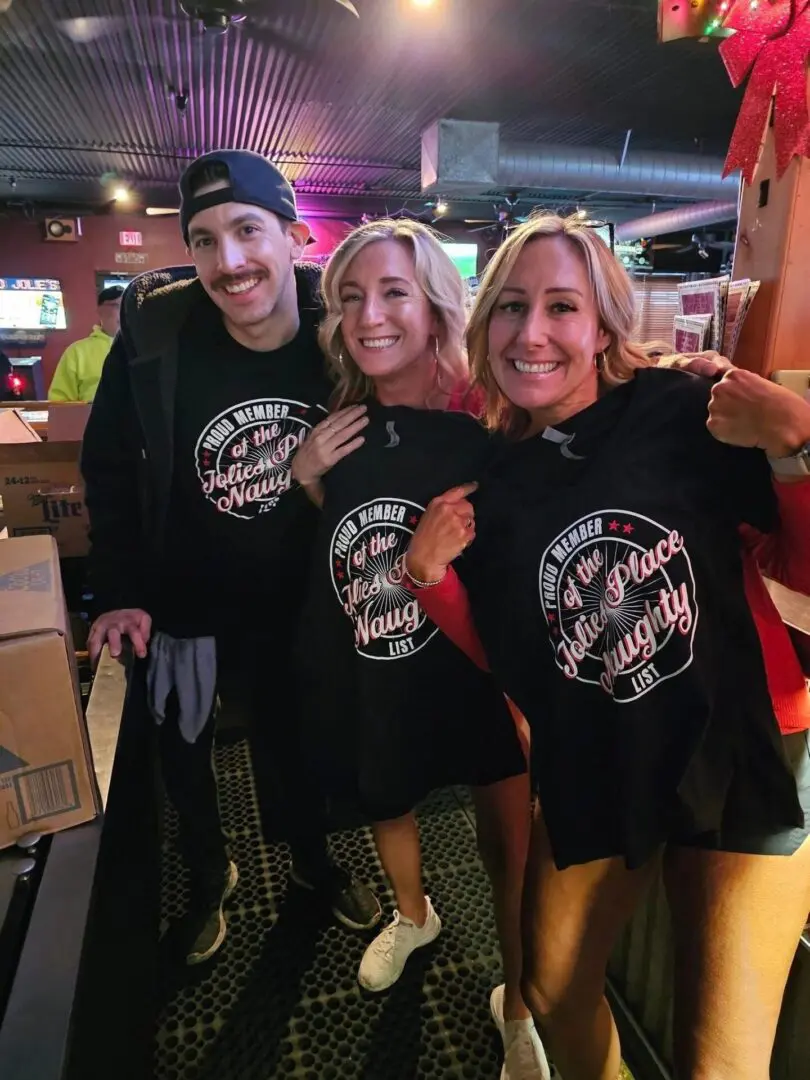 Three people posing for a picture in black shirts.